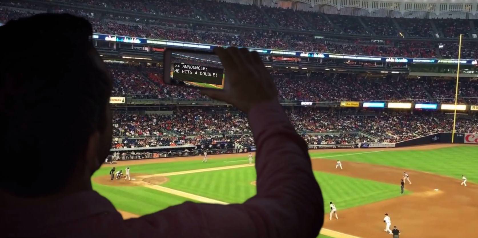 Sports fan reading captions at a live game
