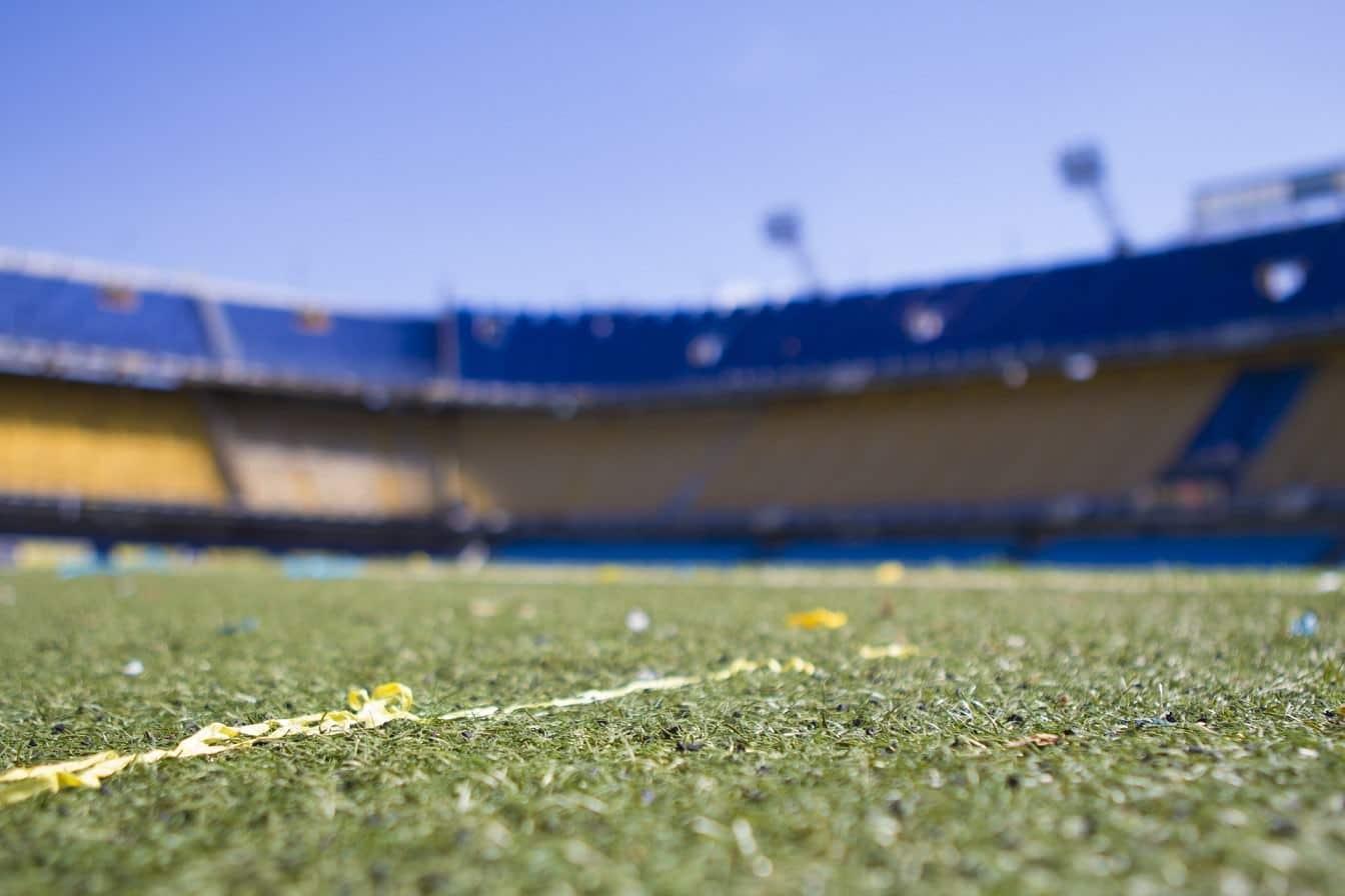 Close-up of a sports field with stadium seats in background