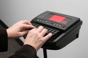 Hands creating captions on a steno machine