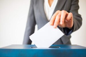 Woman placing vote in a ballot box