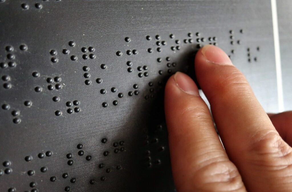 Person reading a Braille notice