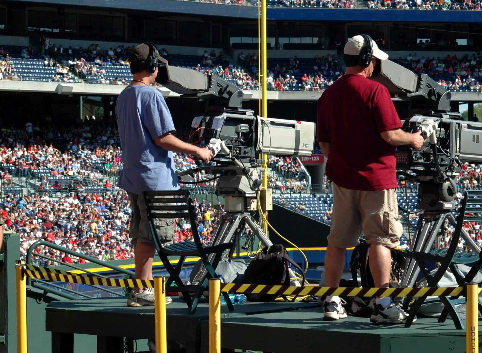 Two TV cameramen filming a sports event