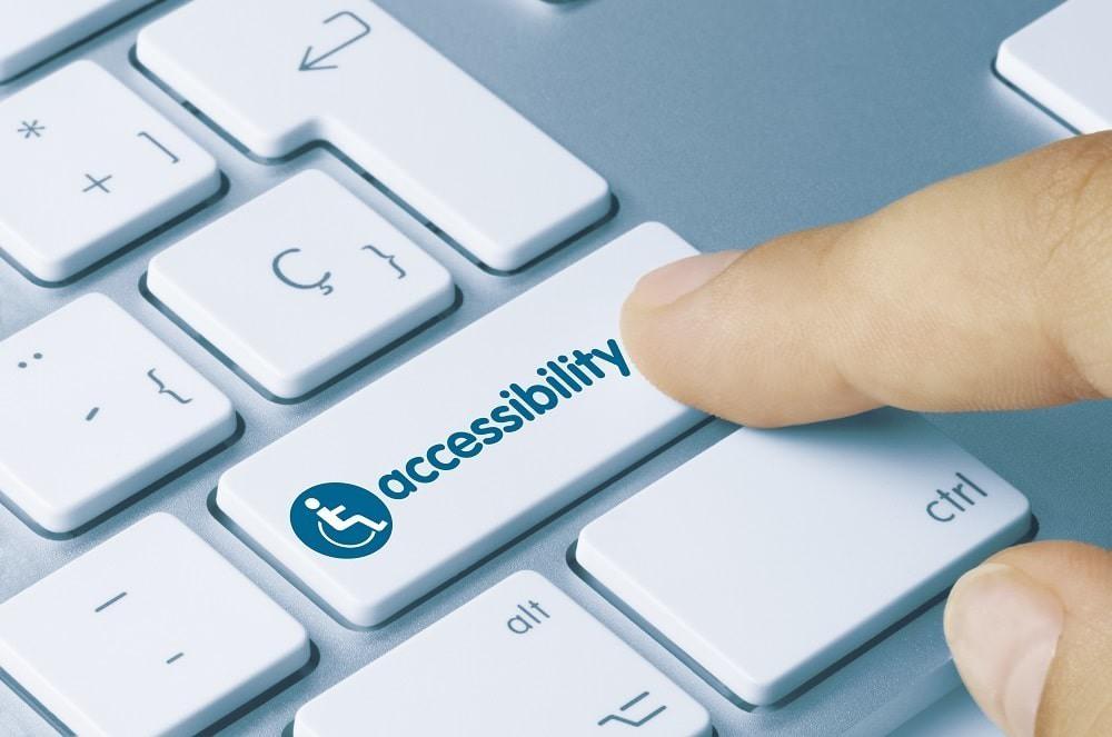 Finger pressing an 'accessibility' key on computer keyboard for DOJ ADA blog