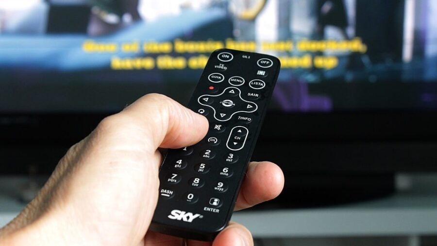 Person using a remote control to watch captions on TV