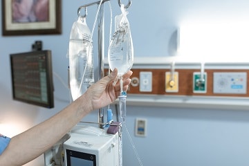 Nurse reaches for an IV bag in a center for ADA blog