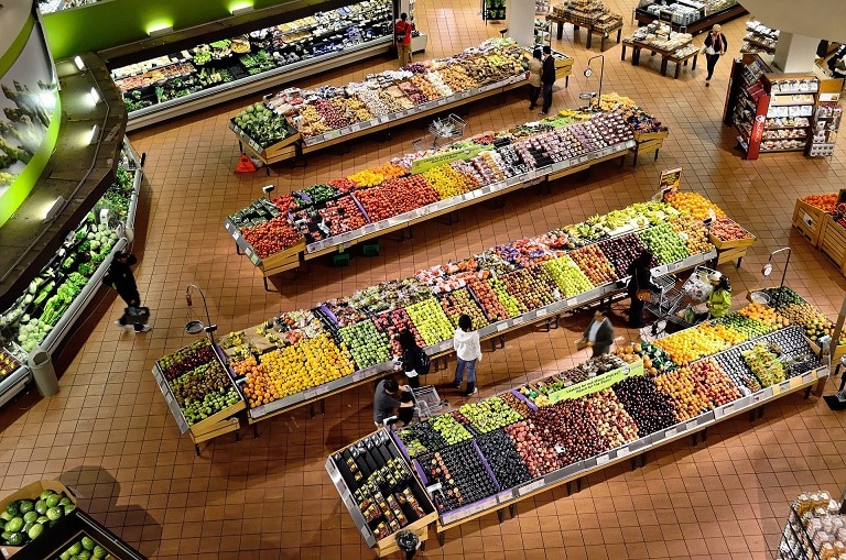 Bird's eye view of a grocery produce department with people shopping for the ADA blog