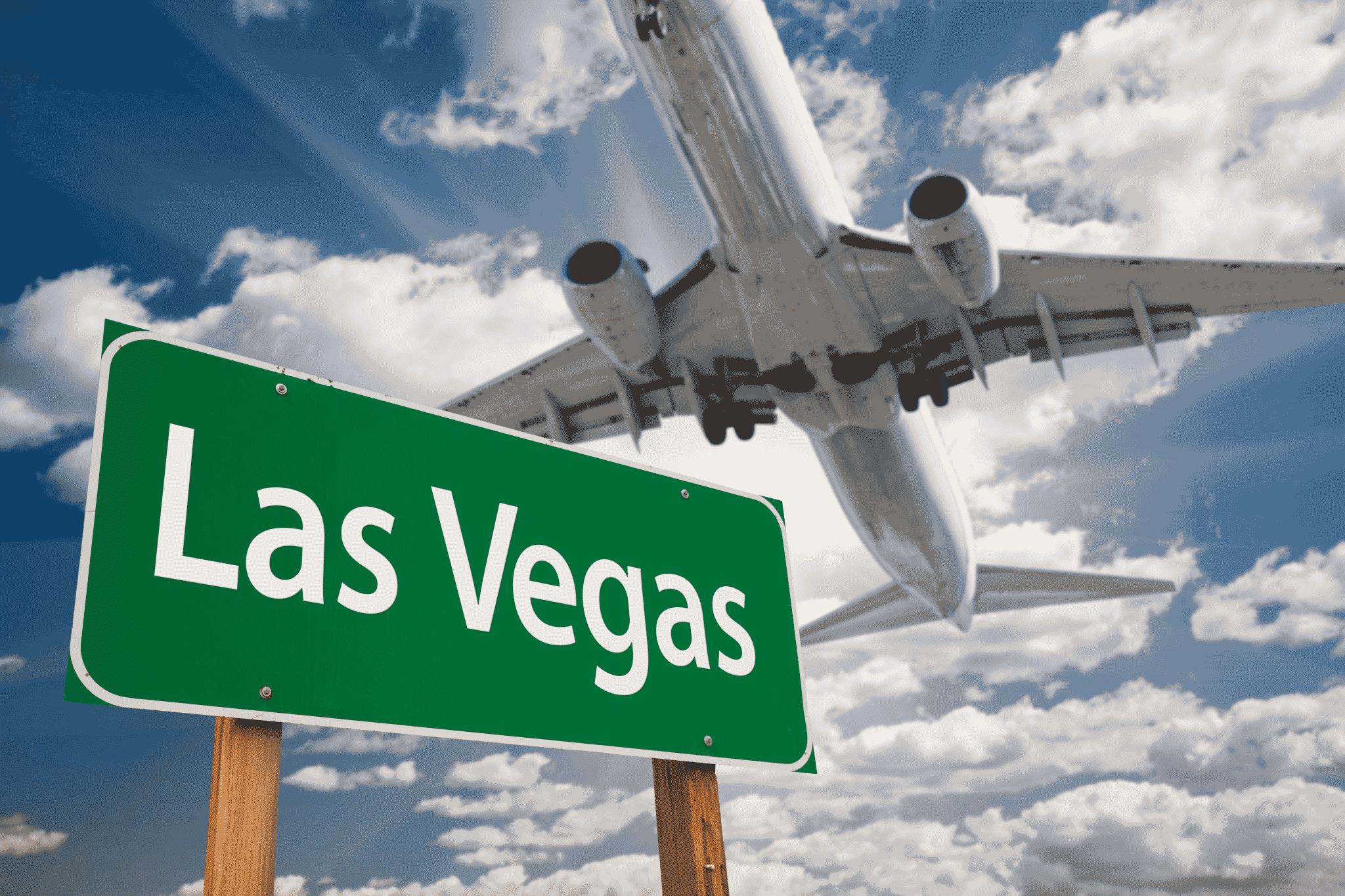 plane flying over direction sign reading Las Vegas