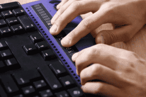 fingers typing at braille keyboard