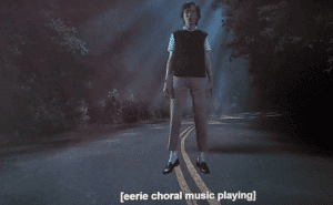 character Fred from the streaming series "Stranger Things" suspended in mid-air with the descriptive caption [eerie choral music playing]