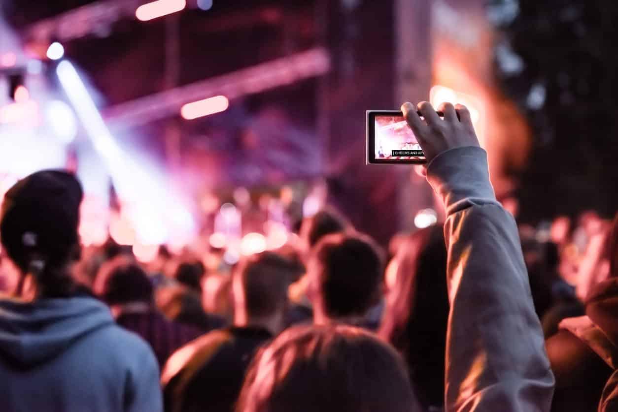 girl-at-concert-holding-phone-with-captions-on-screen-cheers-and-applause