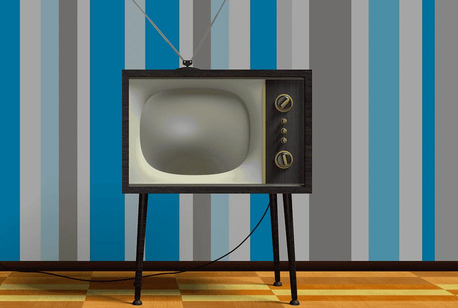 1960s era television set in a living room with blue, gray, and white striped wallpaper and parquet wood flooring