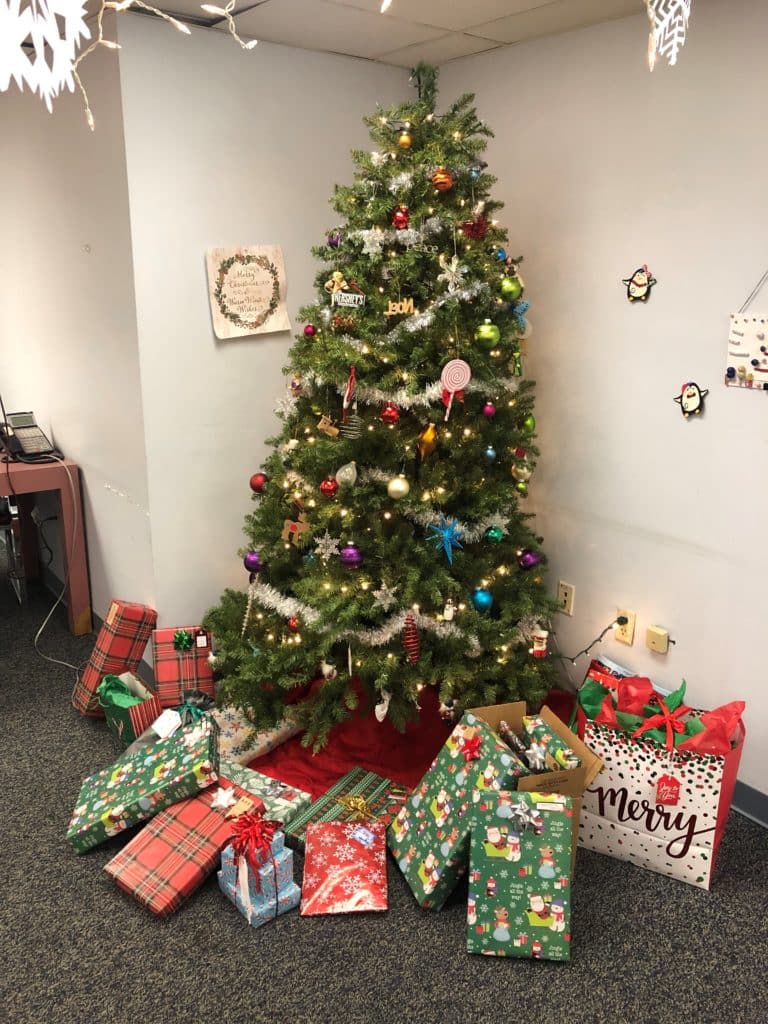 Holiday tree at HDS with VITAC gifts for clients positioned underneath
