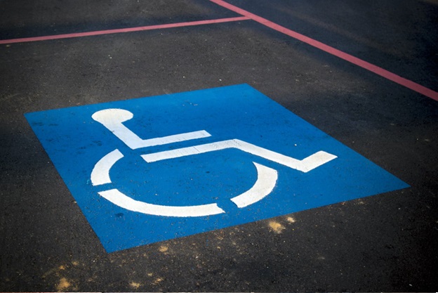 A blue and white handicapped parking space sign painted on the pavement.