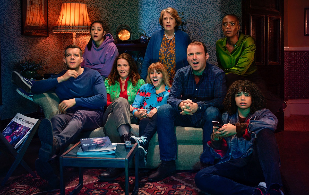Men and women, the cast of Years and Years, sit on a couch watching television